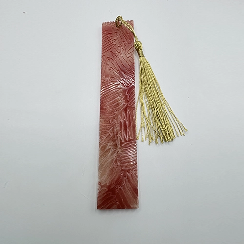 Marque-page artisanal en résine rouge avec pompon doré